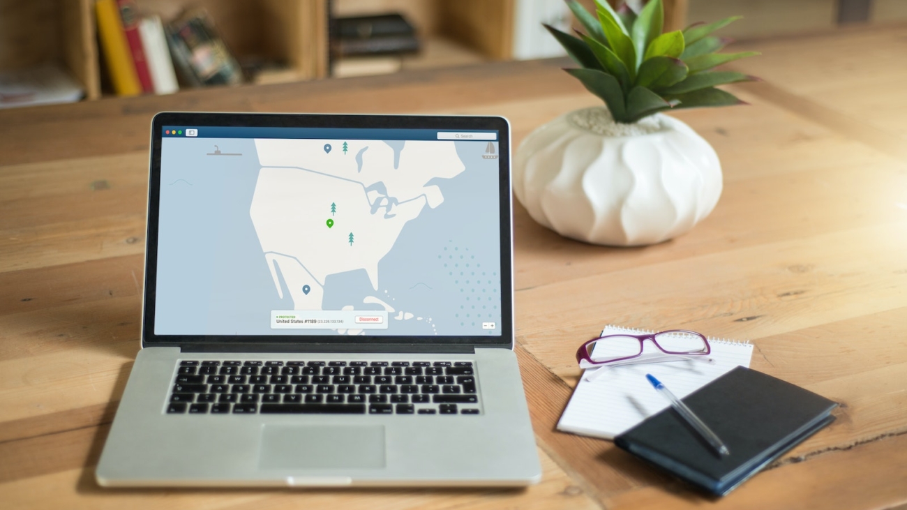 laptop na biurku, obok okulary i notes